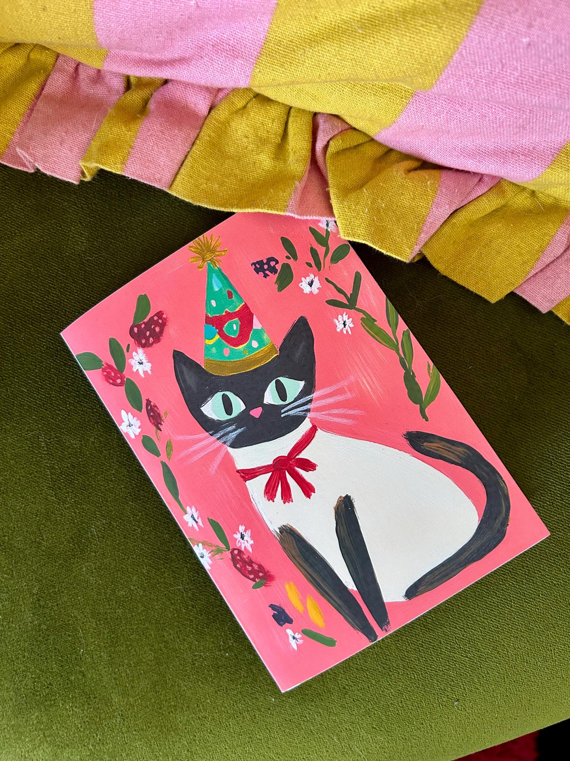 Carte anniversaire chat noir A6 – illustration festive avec chapeau, ruban rouge et fleurs – papeterie mignonne