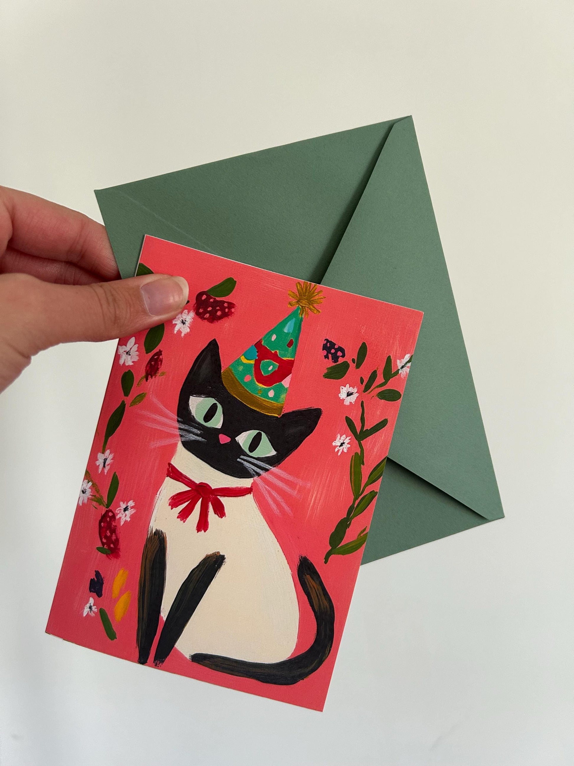 Carte anniversaire chat noir A6 – illustration festive avec chapeau, ruban rouge et fleurs – papeterie mignonne