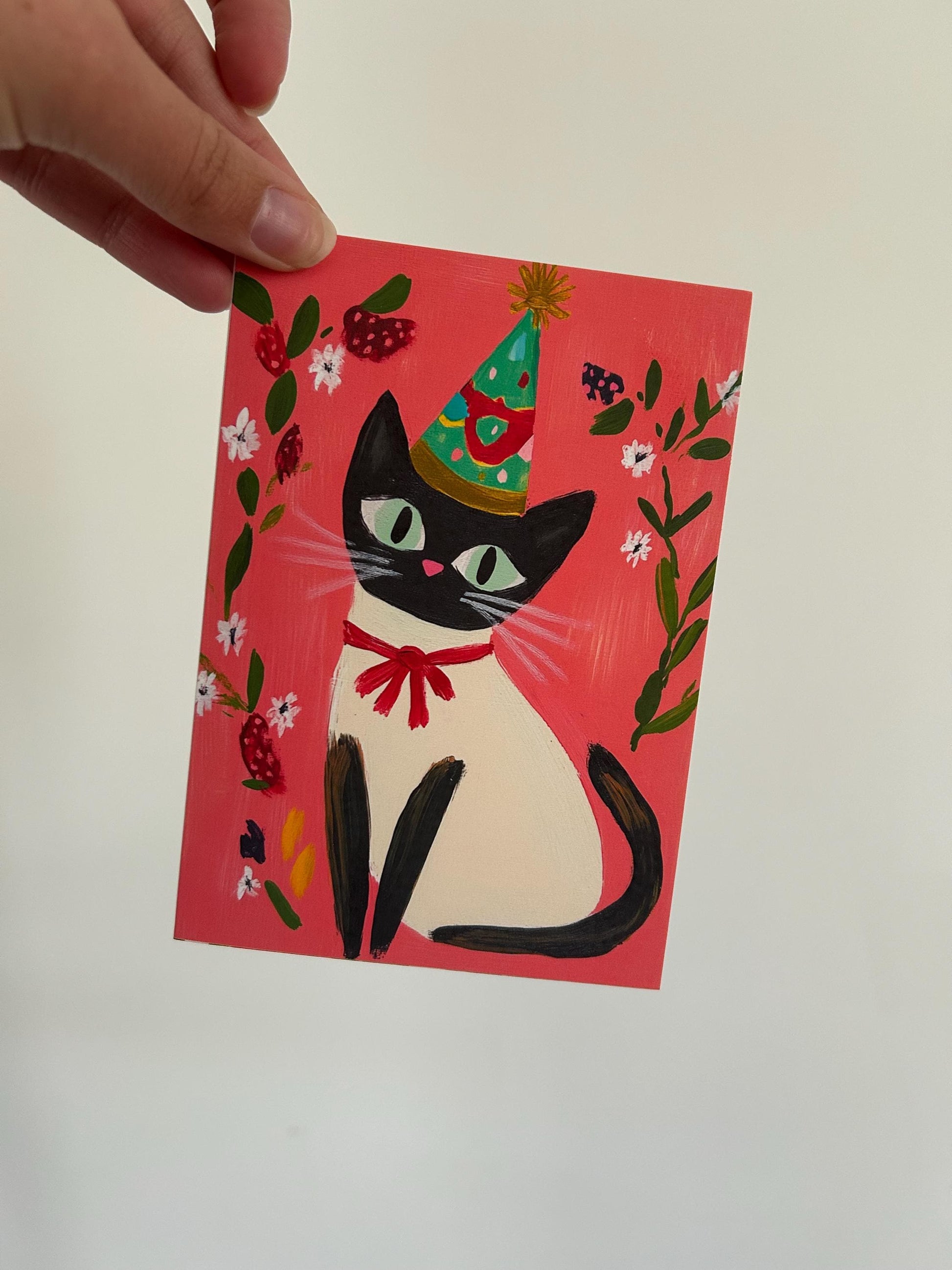 Carte anniversaire chat noir A6 – illustration festive avec chapeau, ruban rouge et fleurs – papeterie mignonne