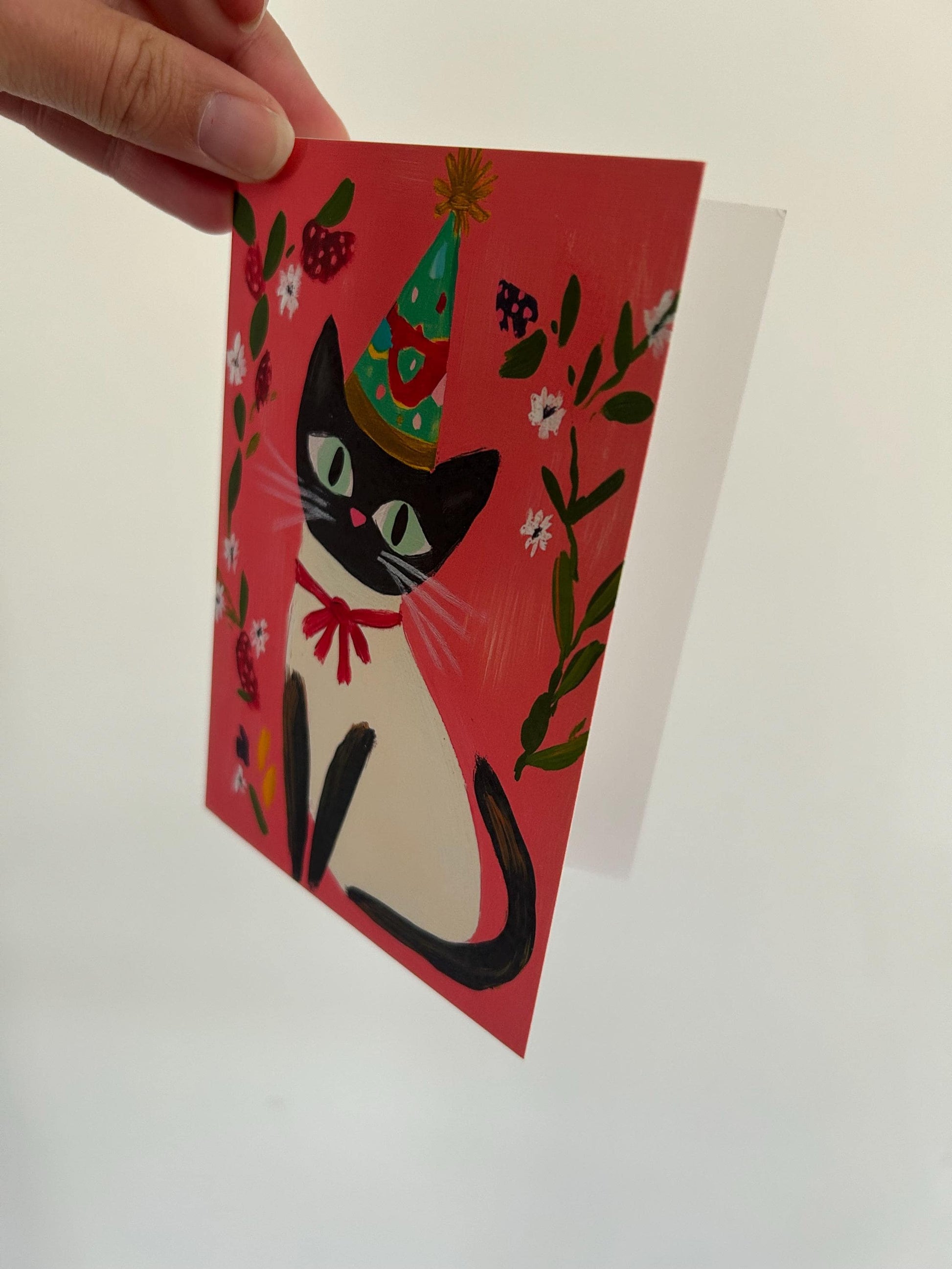 Carte anniversaire chat noir A6 – illustration festive avec chapeau, ruban rouge et fleurs – papeterie mignonne